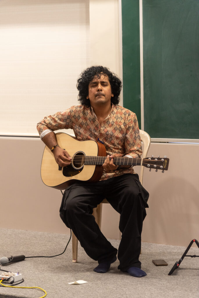Sanket Nashikkar performing acoustic guitar during a Handpan Echoes live music event.