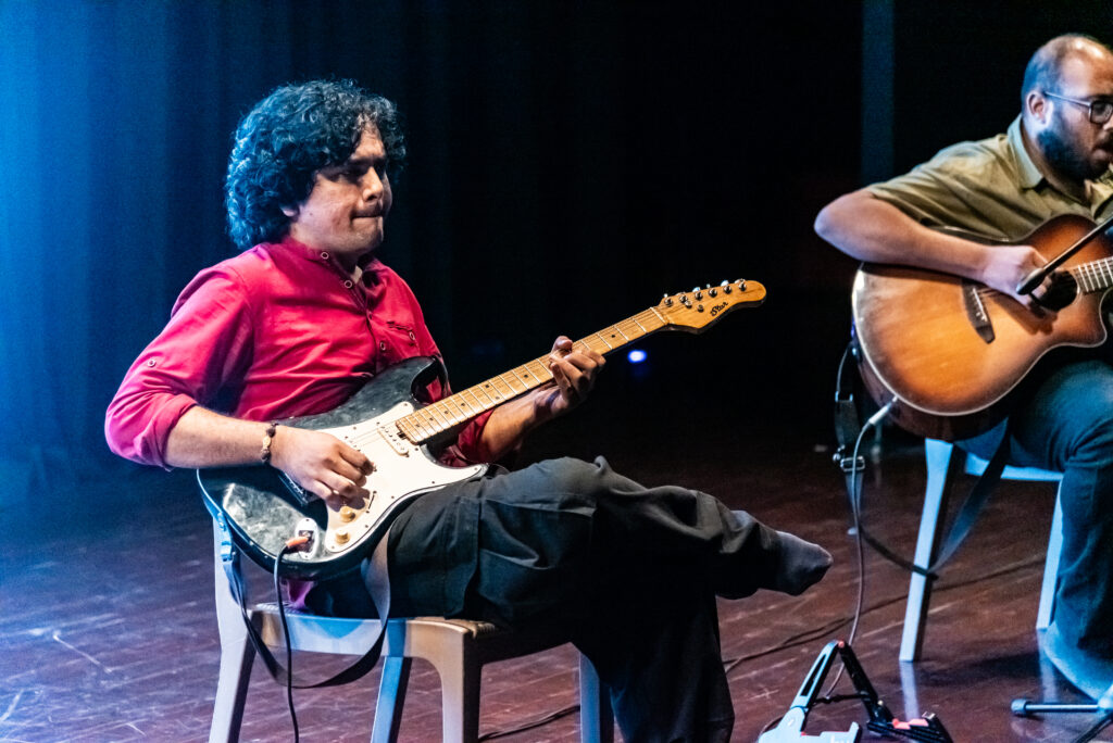 Electric guitarist performing ambient live music during a Handpan Echoes immersive music session.
