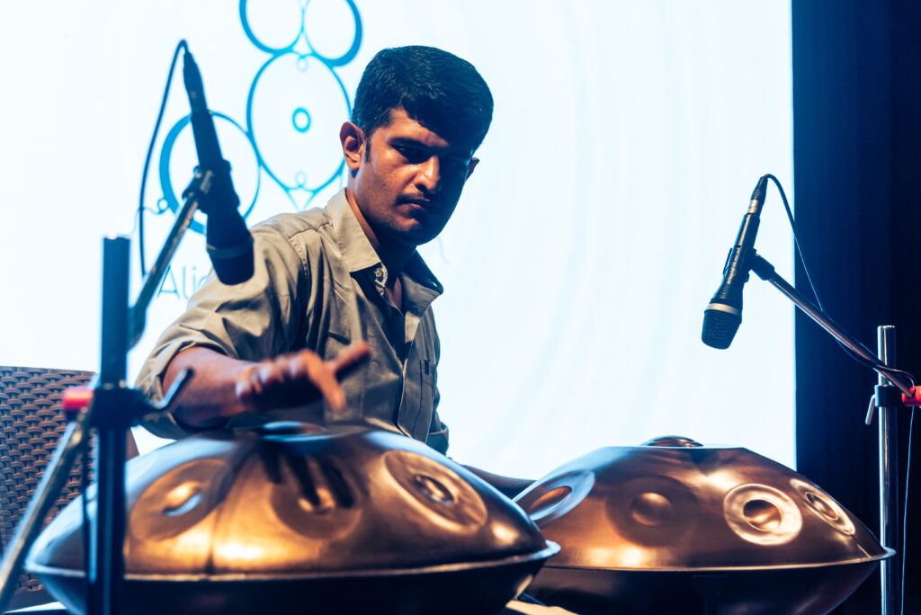 Close-up of a handpan musician performing live during an immersive music event.