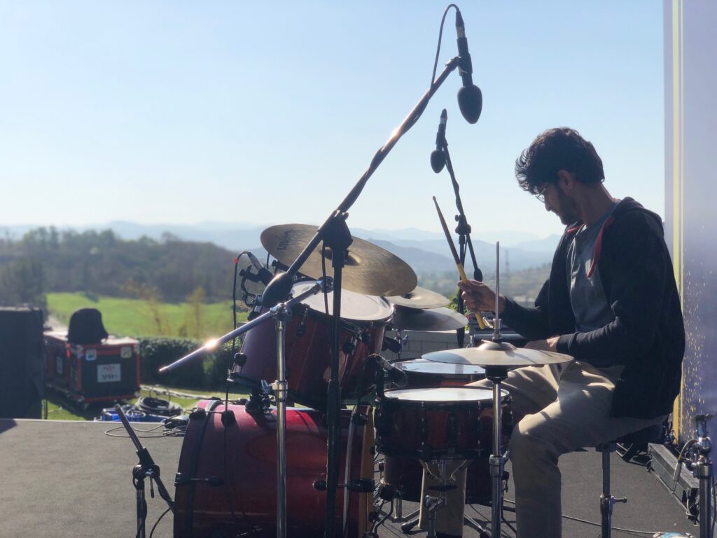 Founder Sagar Belsare performing live drums during an outdoor music event in Pune.